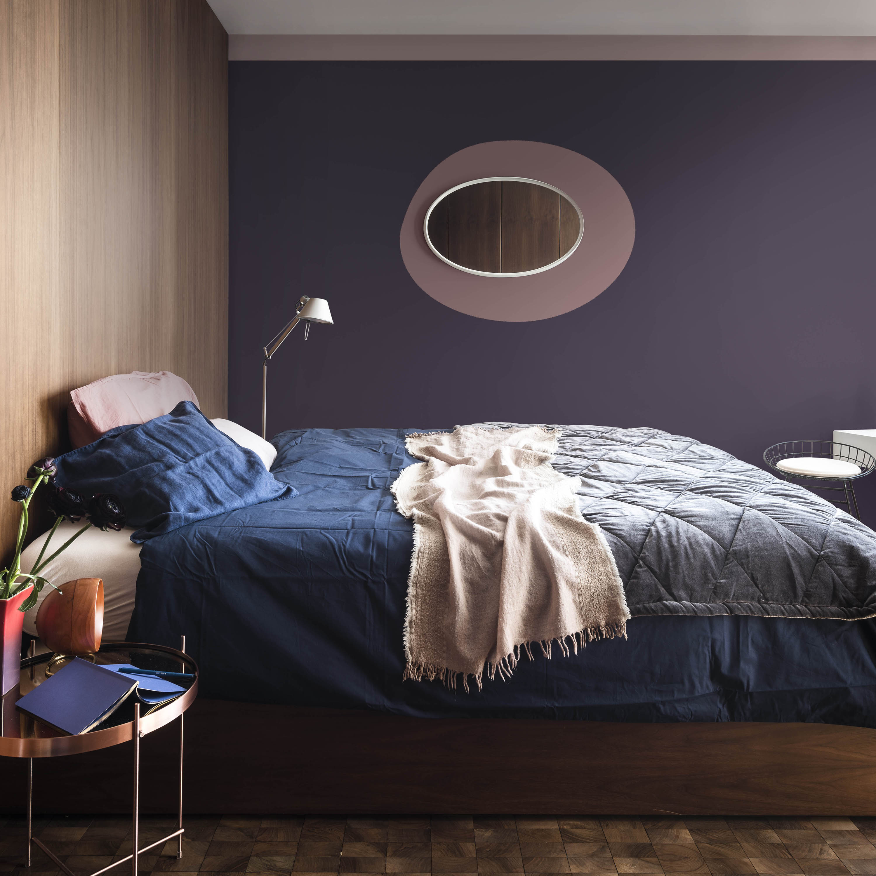 Dark purple bedroom with Heartwood and Blacberry Bush paints by Dulux and round oval mirror
