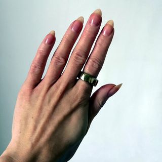 Hand wearing gold ring on index finger