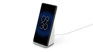 Bästa Google Pixel 7 och 7 Pro-tillbehör: Google Pixel Stand och en Google Pixel-telefon mot en vit bakgrund.