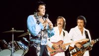 Elvis Presley (left) and James Burton perform onstage