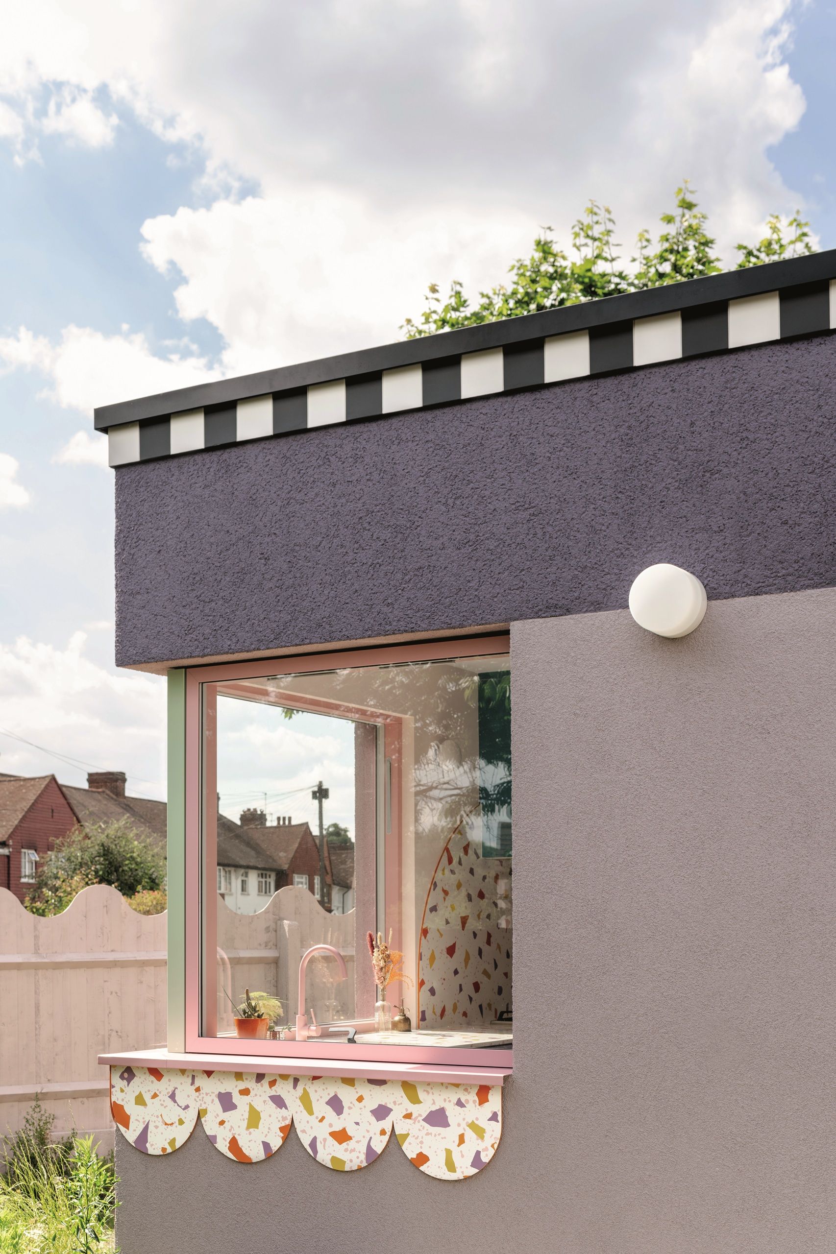 modern extension with purple exterior with striped trim and scalloped terrazzo detail with corner window