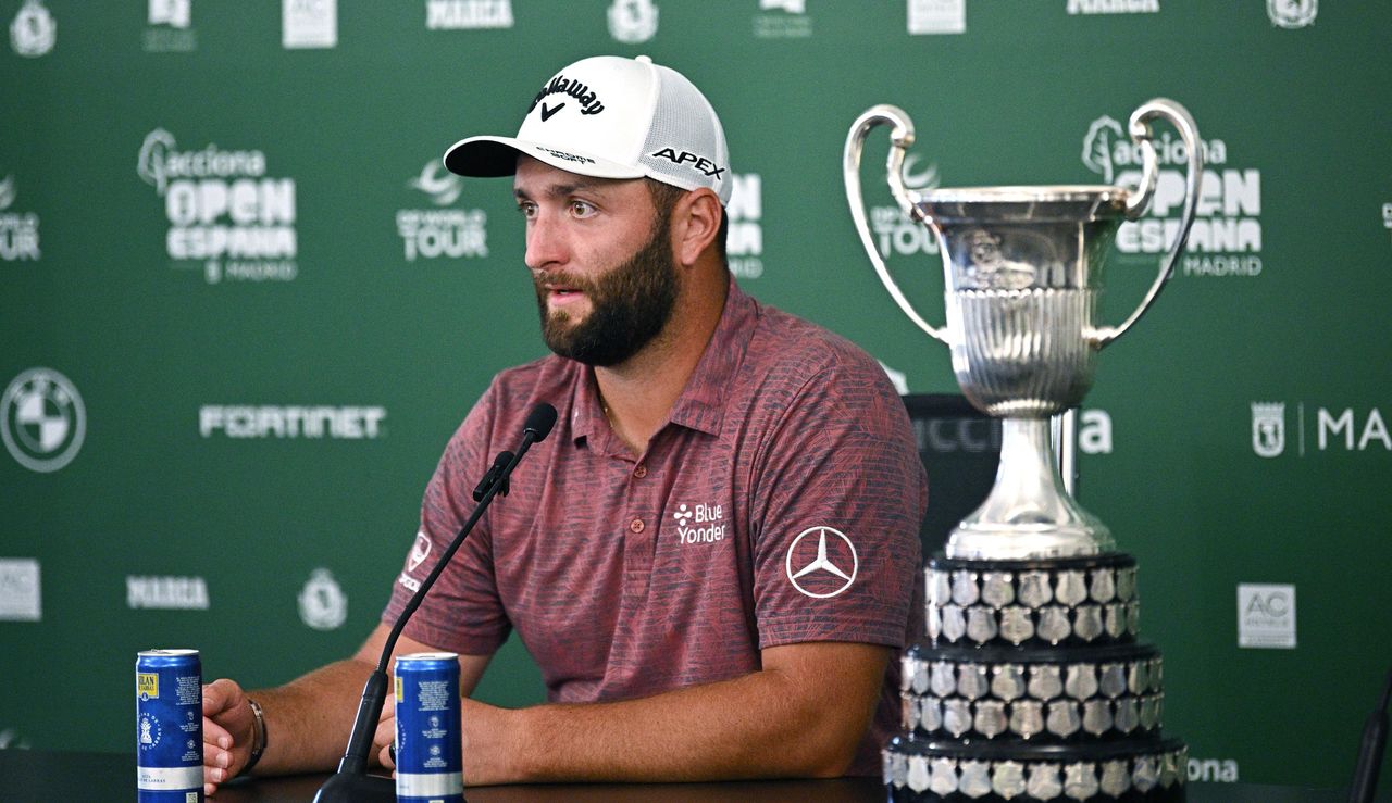 Rahm talks to the media, with the trophy next to him