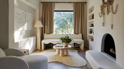 living room with abstract shape rug with fireplace and coffee table and wavy sofa