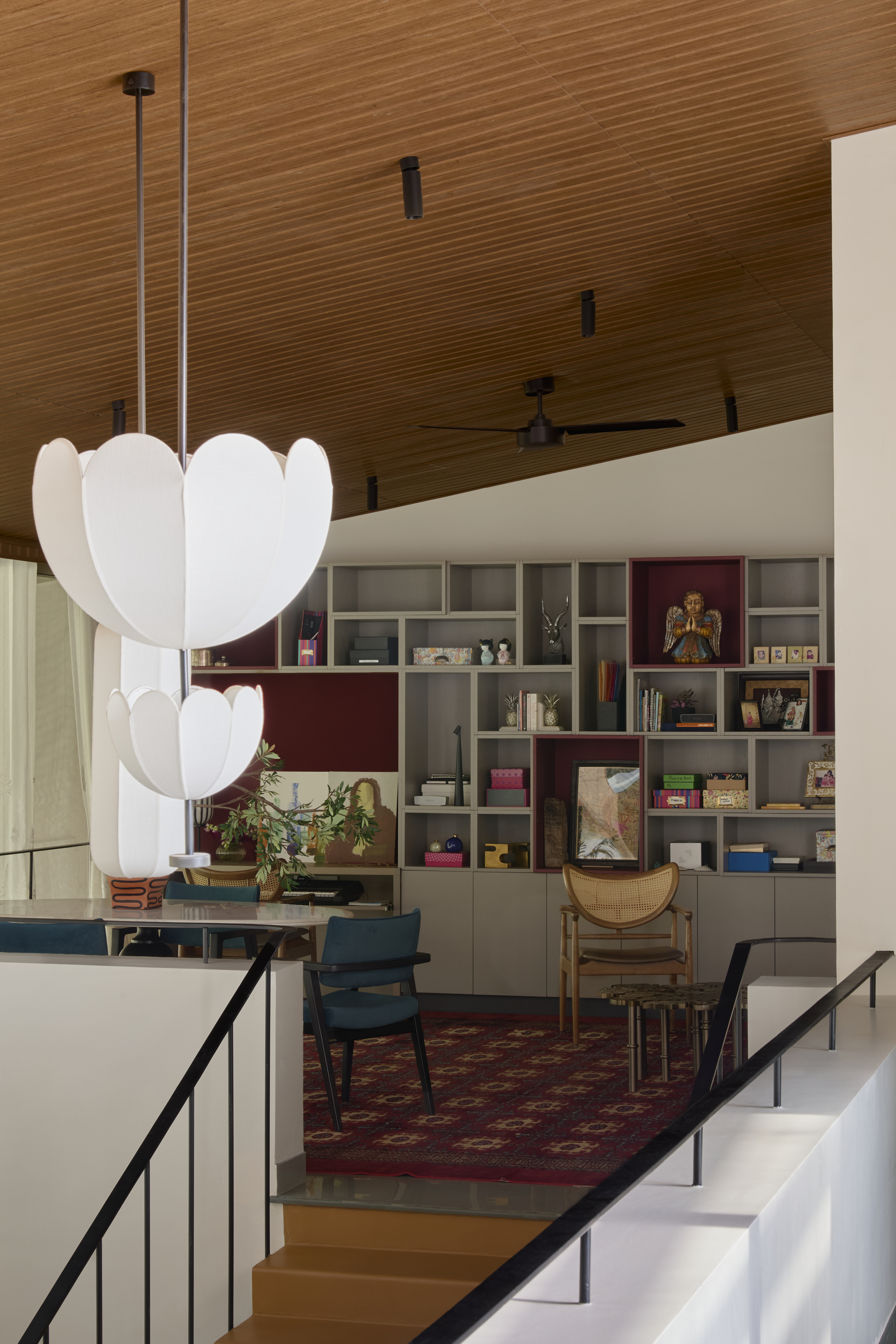 An upstairs area with a red carpet, and flower-shaped ceiling lights