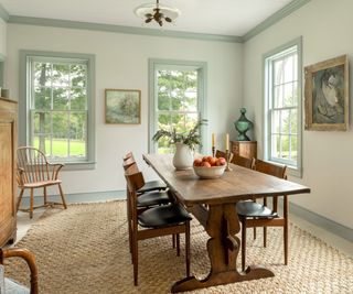 pastel blue green dining room with a large farmhouse table and vintage furniture