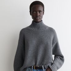 COS model wearing a grey cashmere funnel-neck jumper