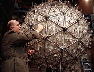 Steven Goldmacher of Philips Lighting Company screws in one of the 168 light bulbs in the Times Square New Year's Eve ball 20 December 1999 in New York