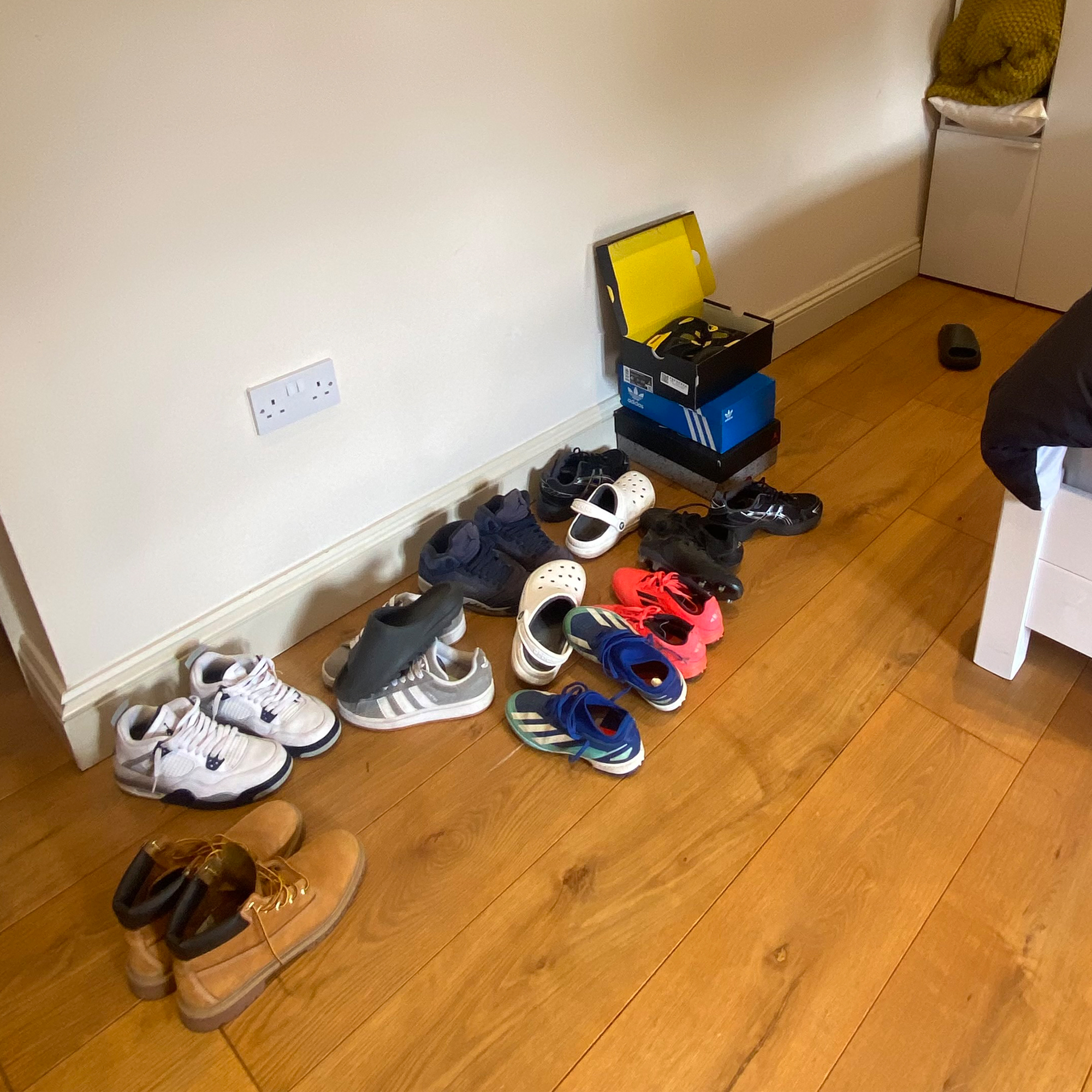A pile of shoes on a kids bedroom floor