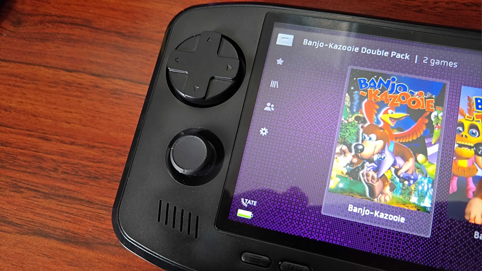 Close up of Evercade Nexus D-pad and thumbstick on woodgrain desk.