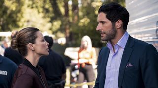 Lauren German (as Chloe Decker) and Tom Ellis (as Lucifere Morningstar) stare each other down at a crime scene in lucifer
