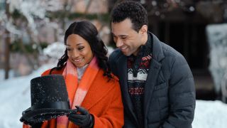 Monique Coleman and Corbin Bleu smile while looking at a photo together in A Christmas Dance Reunion