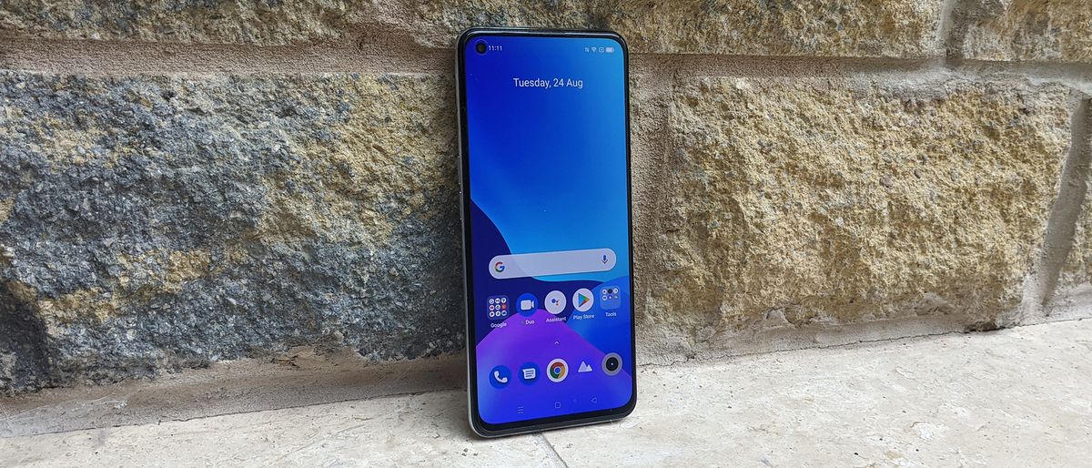 The Realme GT Master Edition facing forwards against a wall.