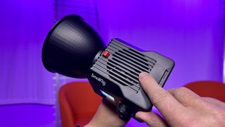 Finger pointing to the top air vent of a SmallRig RC 60B COB video light