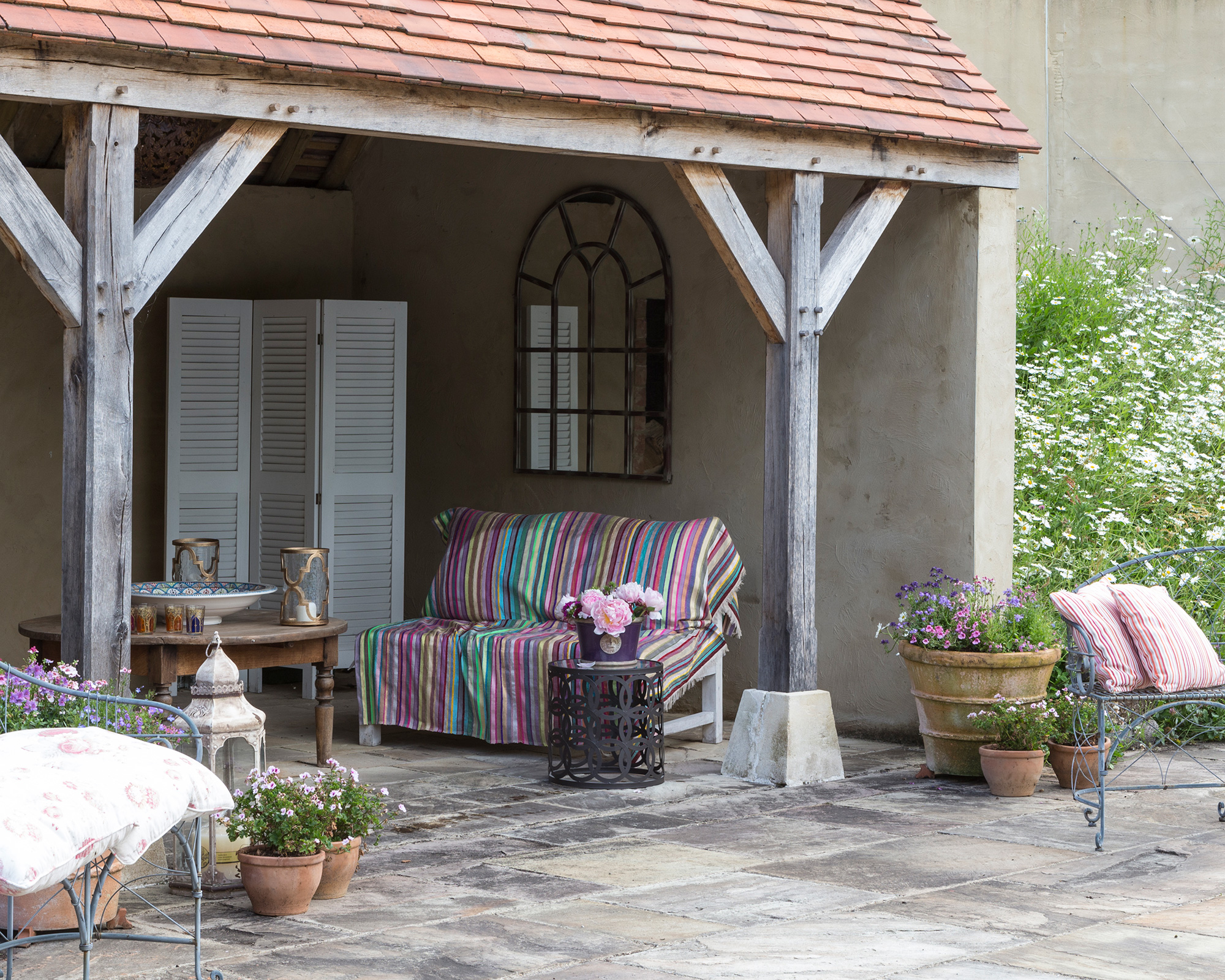 Garden decorating ideas showing a patio with furniture covered with colorful textiles