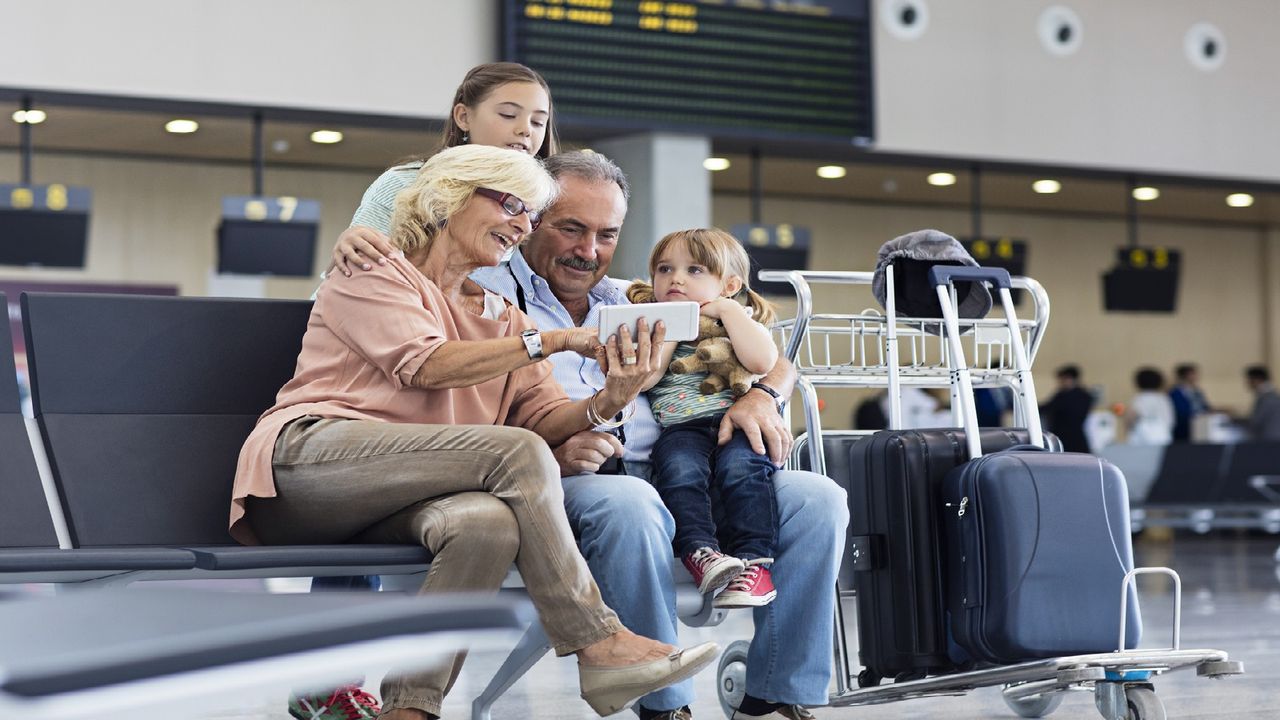 Grandparents and grandchildren wait for their plane at the airport.