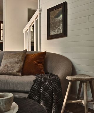 sofa in cabin with white painted wood walls