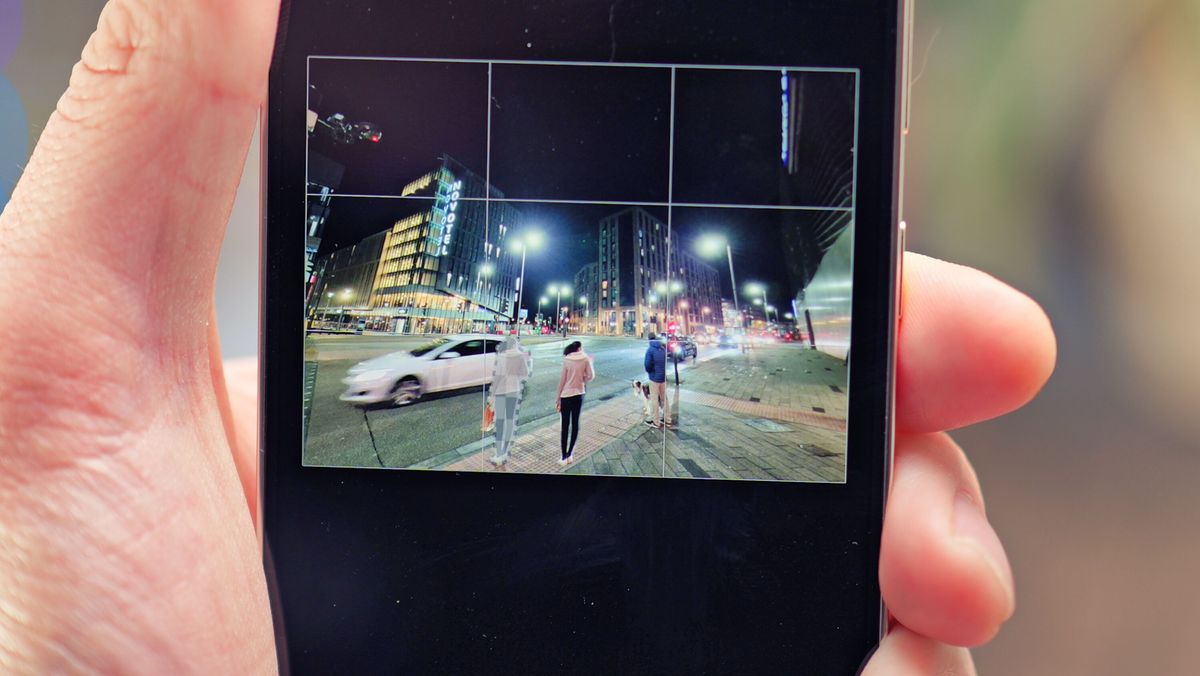 Samsung Galaxy S24 phone held in a hand with the screen showing photo editing software
