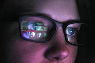 Female cyber security analyst with glasses working on computer