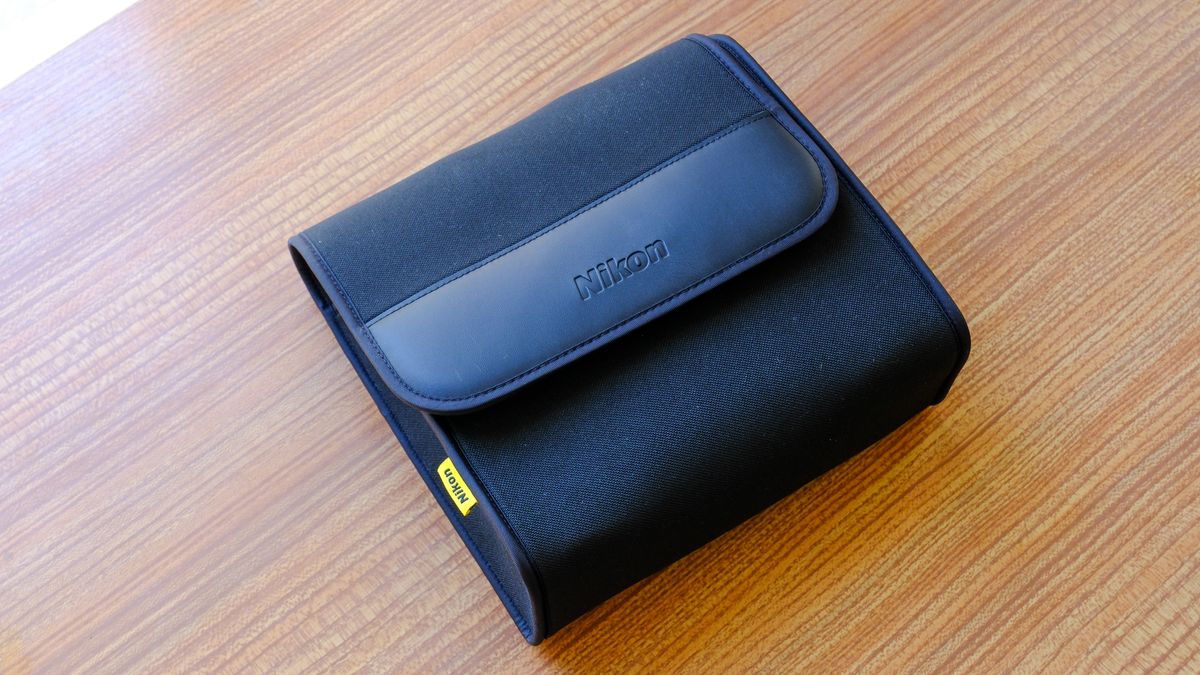 The soft carry case for the Nikon Action 16x50 binoculars on a wooden table. The