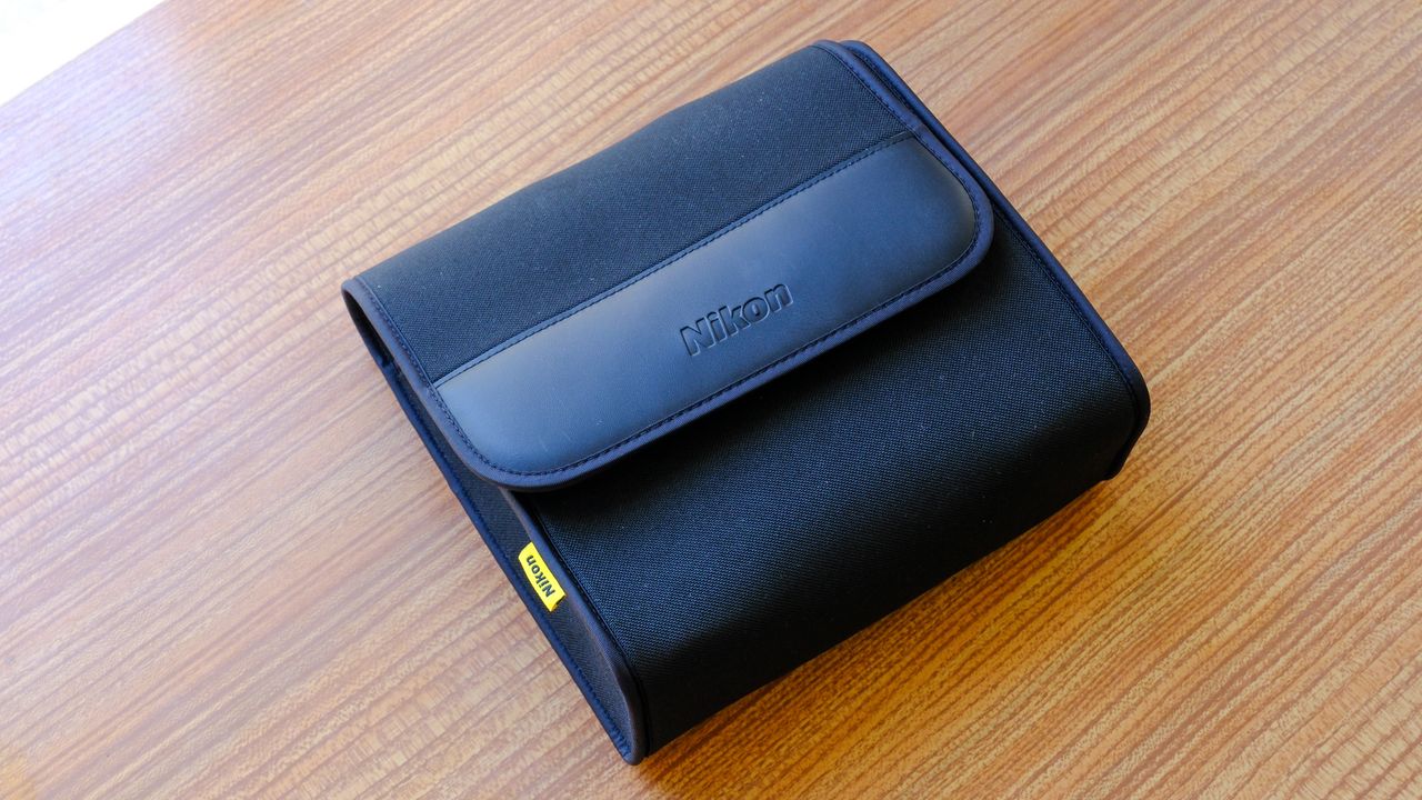The soft carry case for the Nikon Action 16x50 binoculars on a wooden table. The