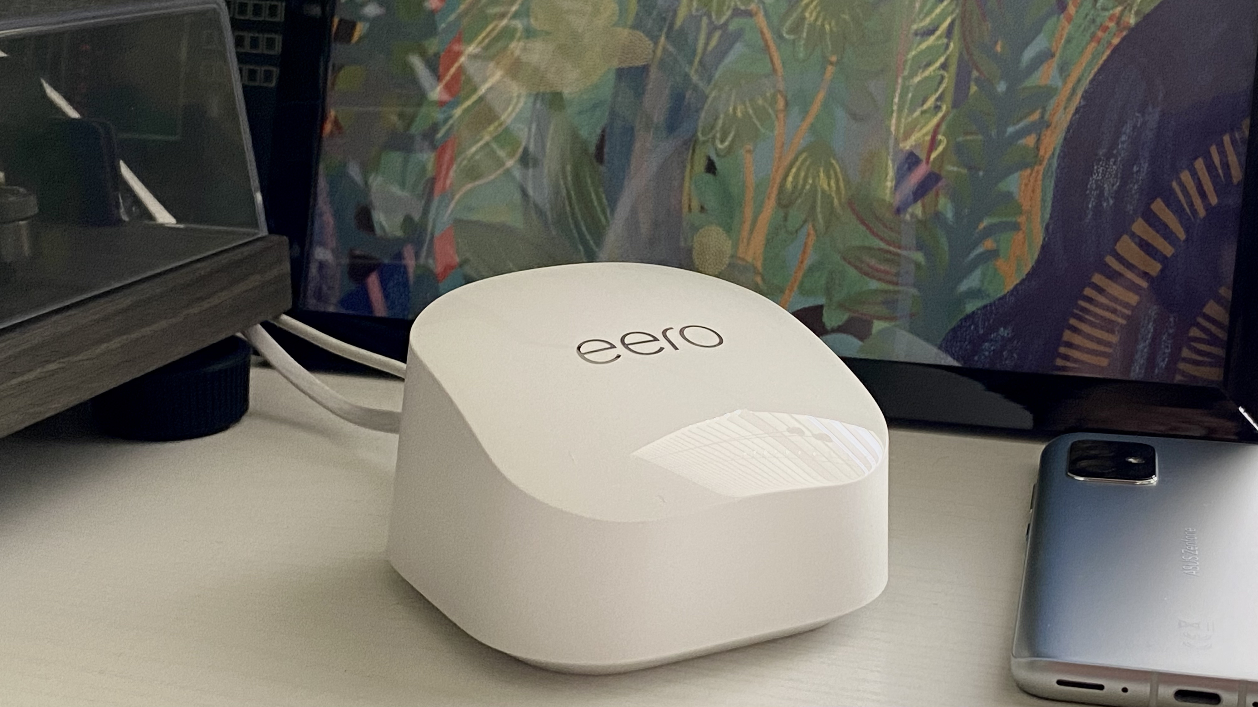 Eero 6+ next to a phone and record player