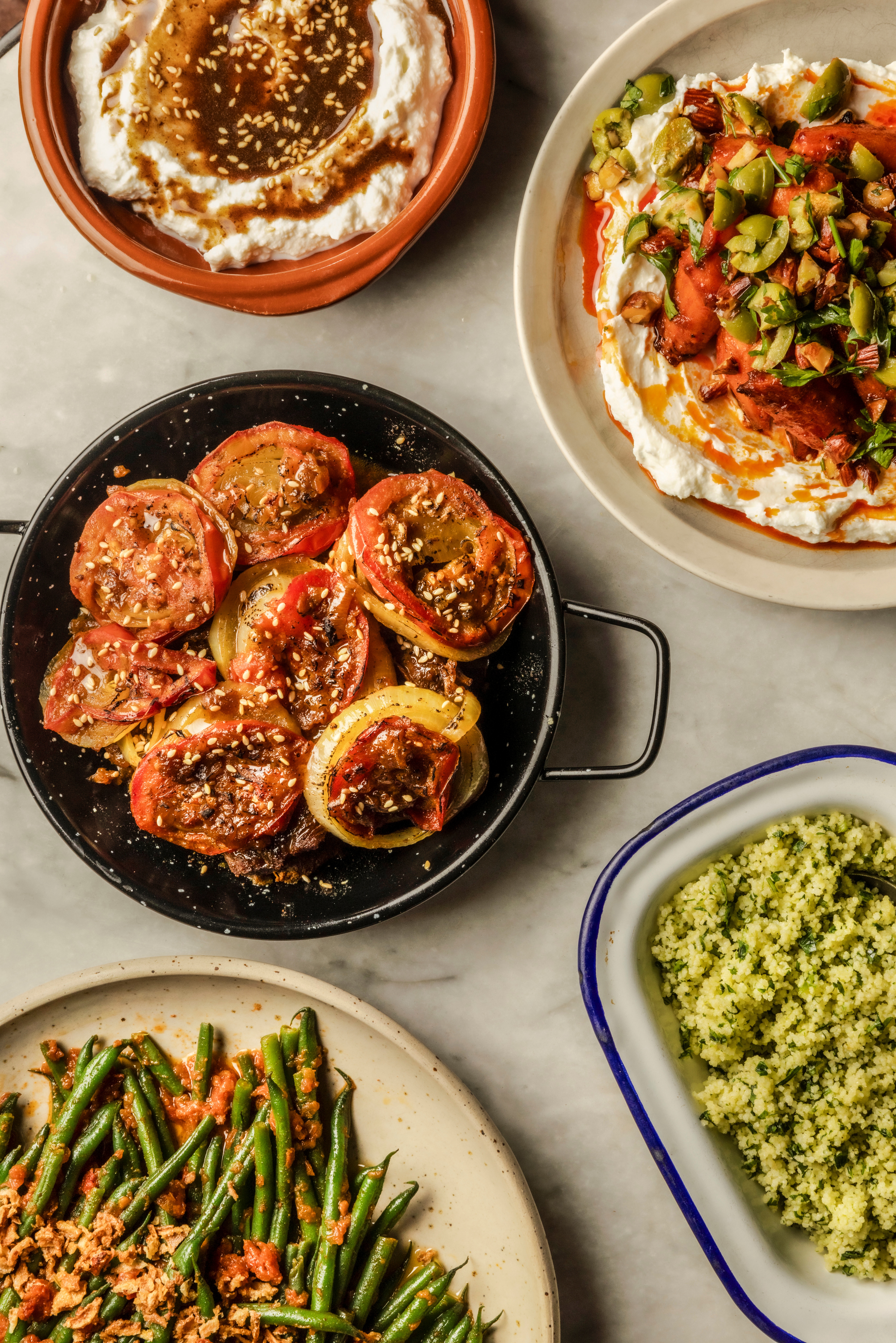 Aerial shots of a table decked up for a meal, covered in lots of colorful plates ready to be shared.