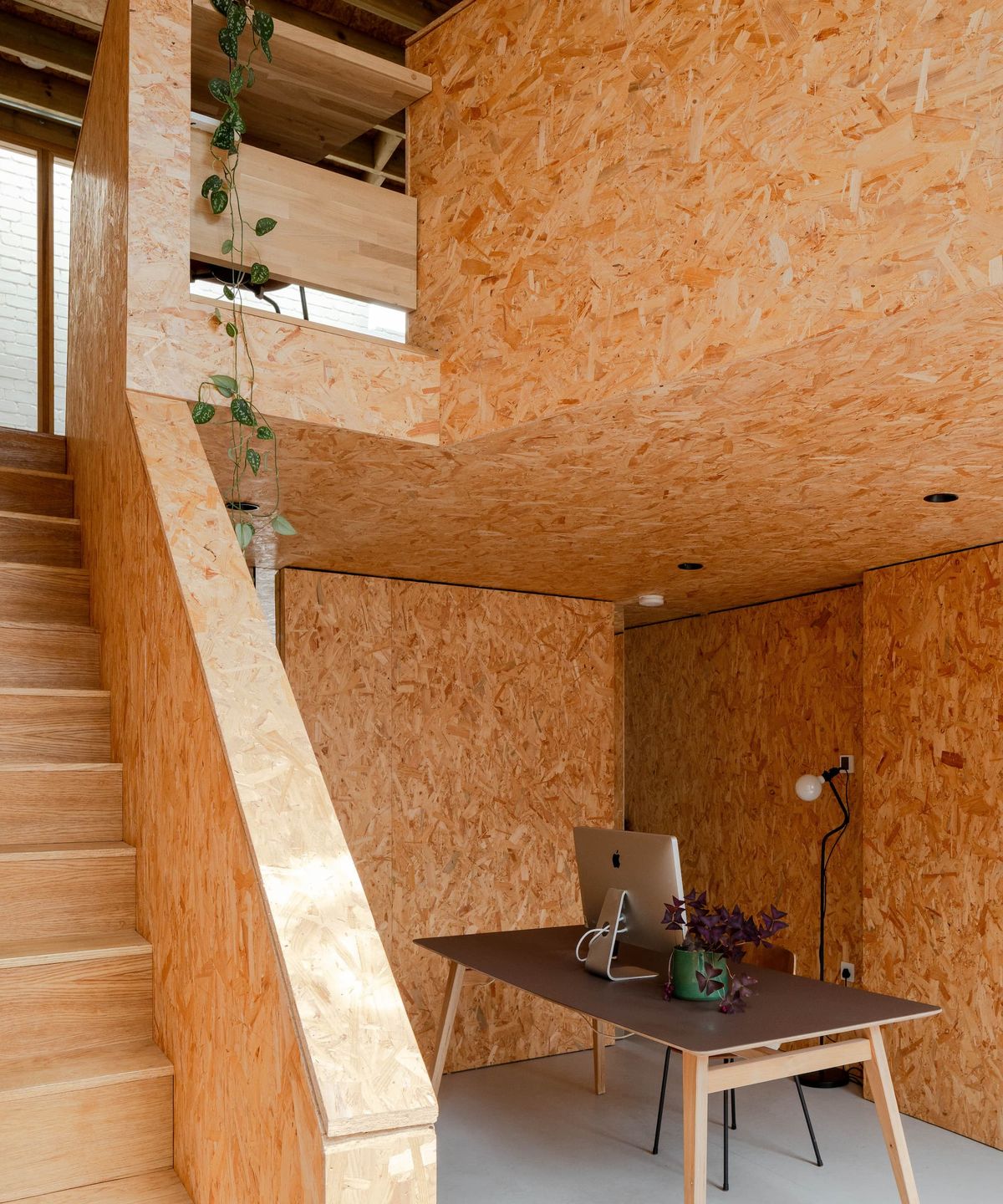 A plywood staircase and small understairs office space