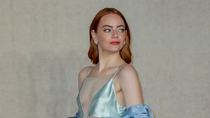 Emma stone stuns in a plunging silk gown while attending a UK Gala Screening of "Poor Things." 