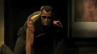 Wesley Snipes in all black and sunglasses, kneeling in Blade 2