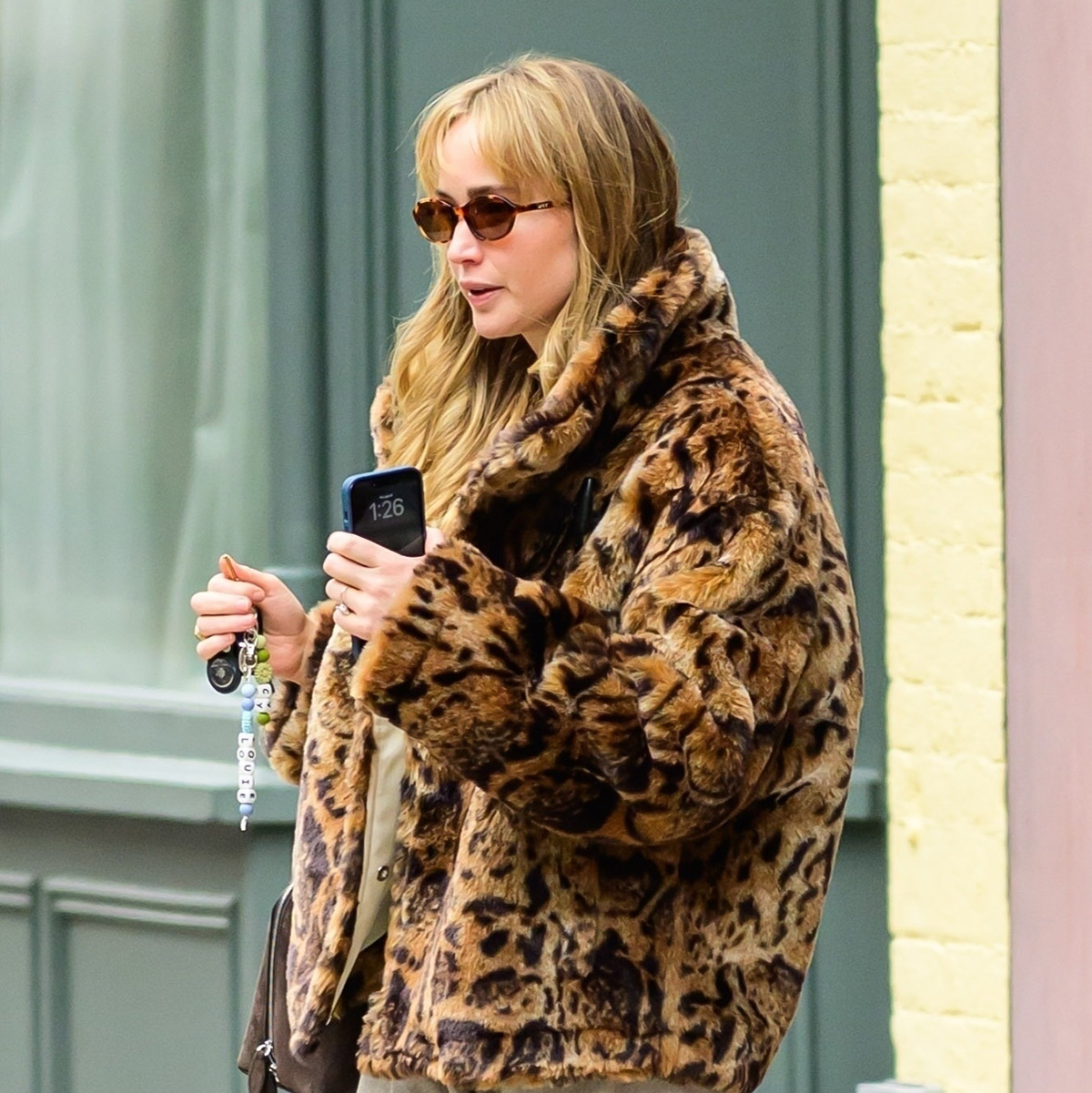 Jennifer Lawrence wearing a leopard faux fur coat, tan pants, and bright blue shoes in NYC