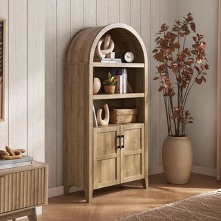 A wooden arched cabinet in a neutral-colored living room