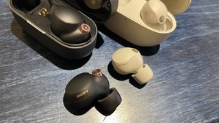 Sony WF-1000XM4 and WF-1000XM5 wireless earbuds out of their case next to each other