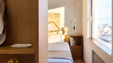 Athens apartment showing bedroom with glimpse of window looking out to concrete cityscape