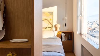 Athens apartment showing bedroom with glimpse of window looking out to concrete cityscape