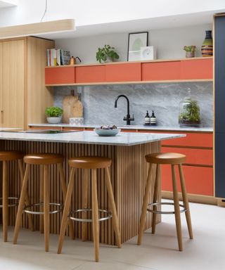 colors you should never paint kitchen cabinets, modern kitchen with orange cabinets base and wall, kitchen island with slatted wood, gray marble countertops and backsplash, bar stools,