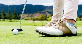 golf shoes with putter and golf ball
