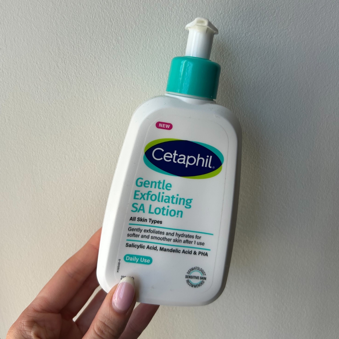 Hand holding empty bottle of Cetaphil Gentle Exfoliating Salicylic Lotion