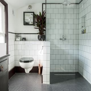 bathroom with white tiles and potted plant