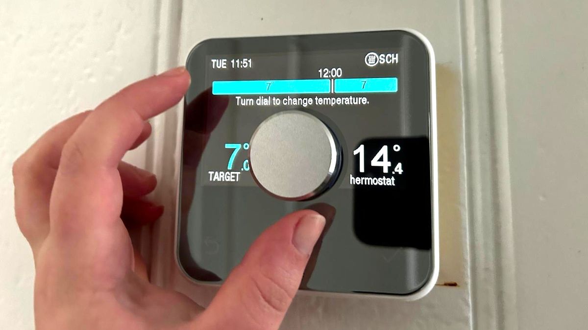 Person's hand turning the main control dial of the Hive Smart Thermostat, which is number four in our guide