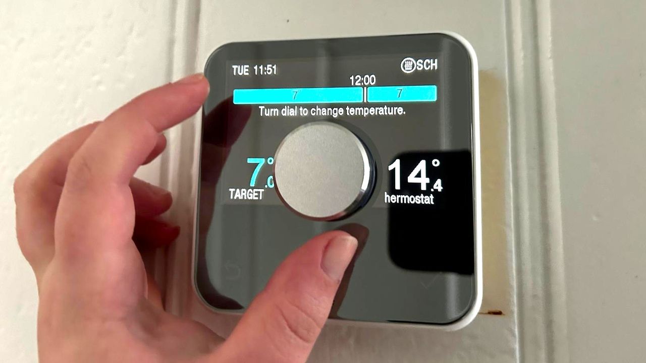 Person's hand turning the main control dial of the Hive Smart Thermostat, which is number four in our guide