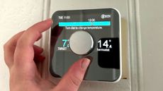 Person's hand controlling Hive Smart Thermostat manually