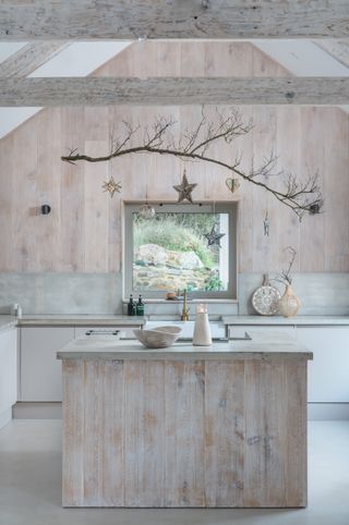 Modern rustic wood clad kitchen with Christmas decor branch and hanging stars