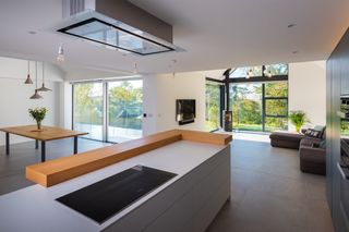 Contemporary kitchen opening into a living area behind