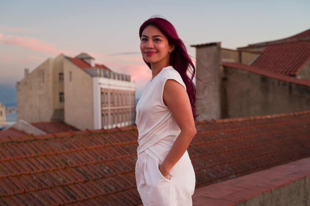 Sigma FP2 sample gallery: woman with pink hair wearing a white jumpsuit, stood on rooftops in Lisbon, Portugal