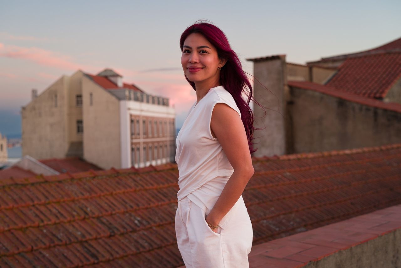 Sigma FP2 sample gallery: woman with pink hair wearing a white jumpsuit, stood on rooftops in Lisbon, Portugal