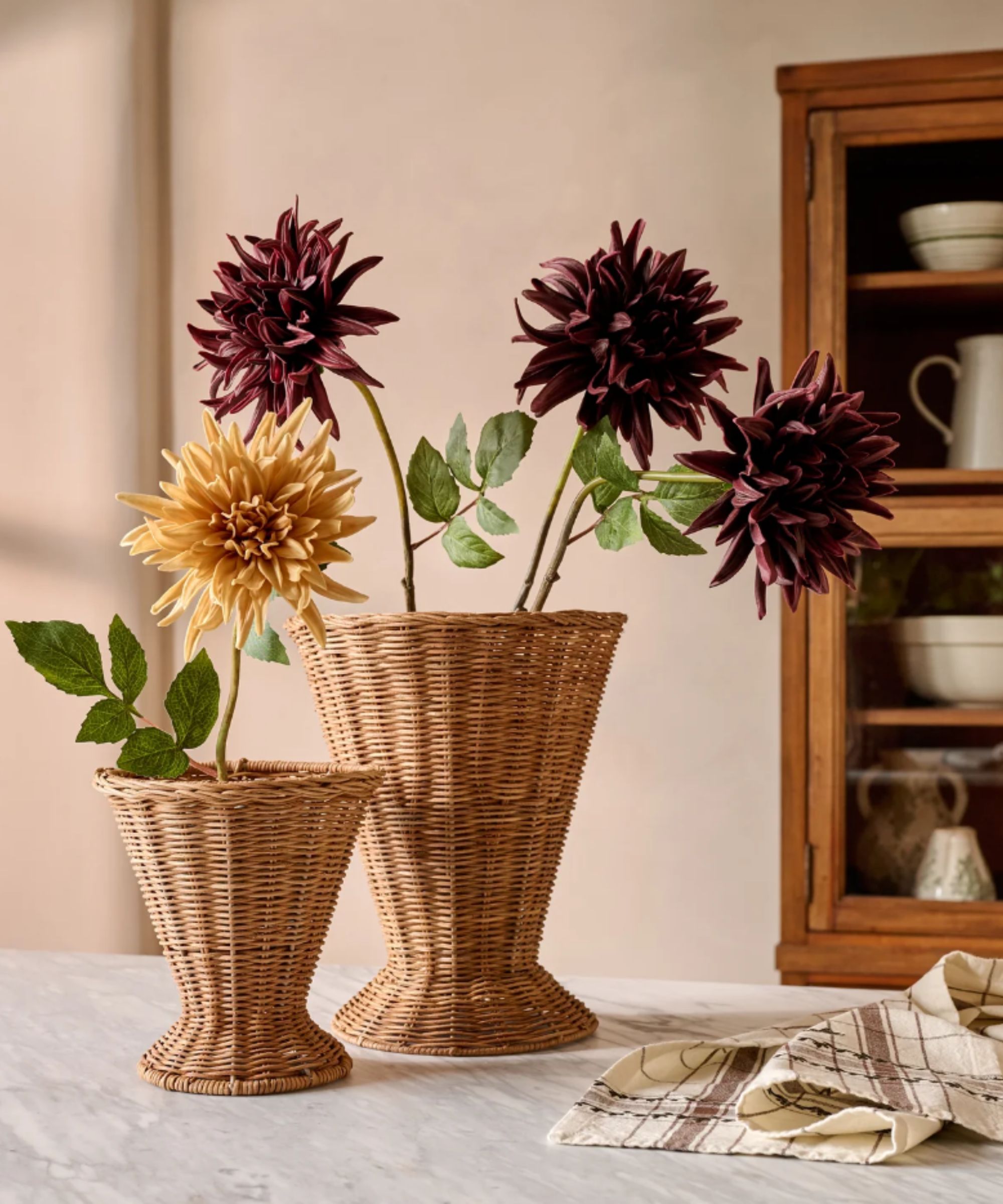 Yellow and burgundy faux dahlias in rattan vases