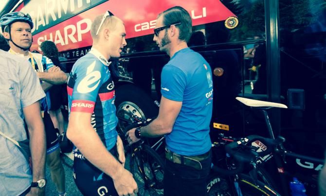 Andrew Talansky talks with his soigneur as he prepares the bikes for the race.