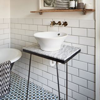 bathroom with bathtub white tiled walls and printed tiled flooring
