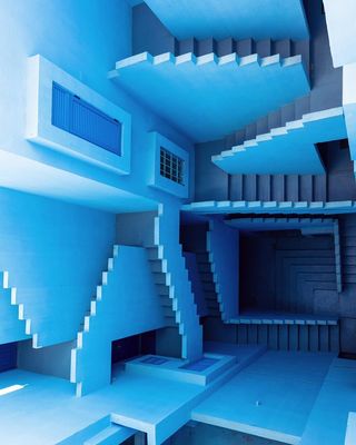View from above of blue, optical illusion style walls and stairs running across multiple levels at La Muralla Roja by Ricardo Bofill in Calp, Spain