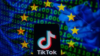 TikTok icon displayed on a phone screen with in the background European Union flag with cyber code, seen in this photo illustration.